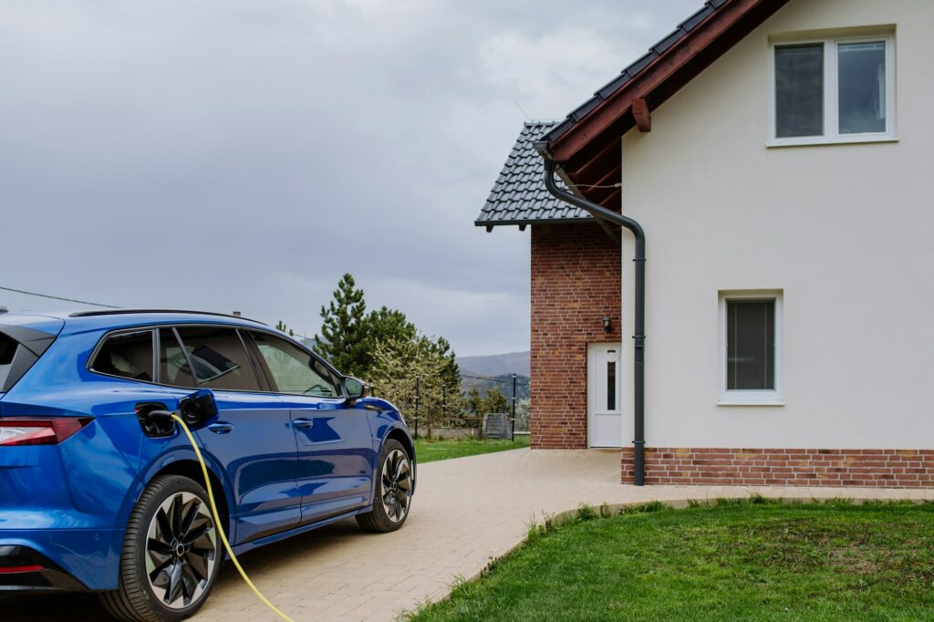 Close-up of electric car charging near family house.